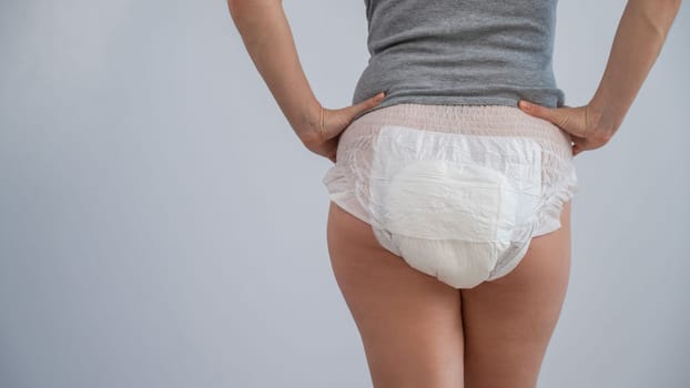 Rear view of a woman in adult diapers. Incontinence problem.