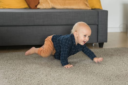 Nursery baby boy crawling on floor indoors at home - Baby curiosity and child development stages