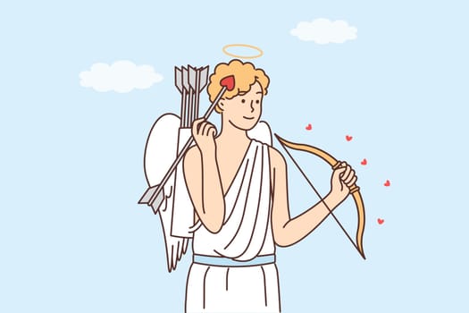 Ancient Greek god cupid with bow and arrow with tip in form of heart stands wanting to give love
