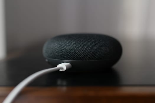 Paris, France - 20 September , 2021: Black physical microphone switch button with cable of the Google Home Mini