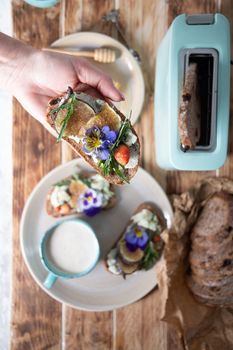 delicious bruschetta with homemade bread, garnished with fig,soft cheese,pansies