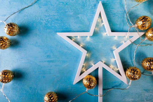 White Christmas star with yellow lights on blue background
