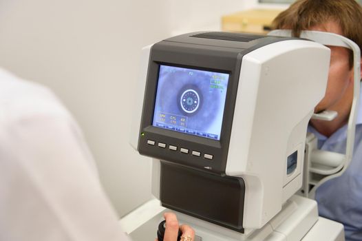 the optometrist controls the oculist display with the scanned eyes of the man, diagnostic ophthalmological equipment