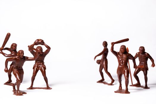 Large toy figures of primitive people on a white background