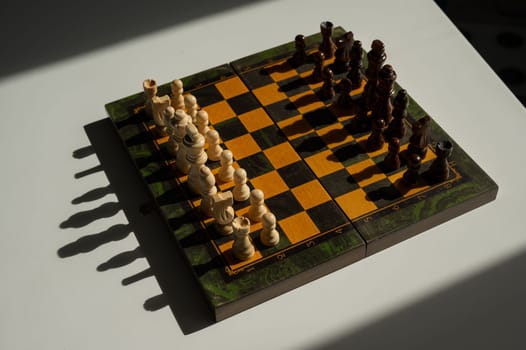 Chessboard with pieces on a white table.