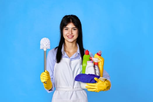 woman in gloves holding bucket of detergents