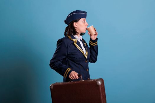 Stewardess in professional airline uniform carrying baggage