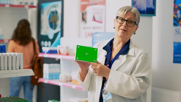 Medical assistant holding box of drugs with greenscreen
