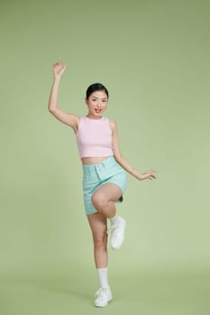 Full-length portrait of amazing asian girl posing with hands up