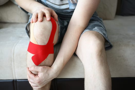 Sick man knee is sealed with kinesio tape