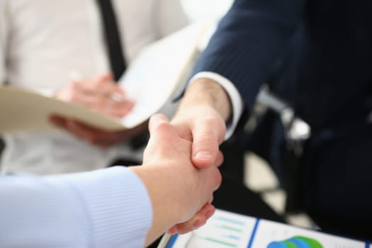 Two business people shake hands after business interview in conference room in office