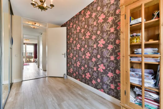 a hallway with a floral wallpaper and a wooden closet