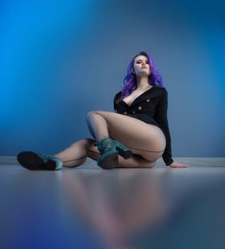sexy girl in a fashionable jacket and with purple hair poses erotically in her underwear