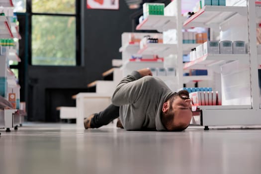 Unconscious person lying on pharmacy floor during epileptic attack