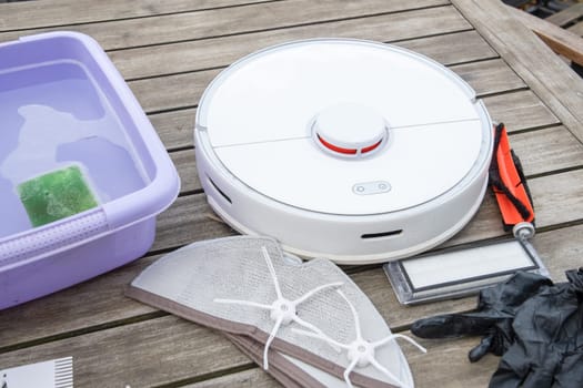 woman washing a trash can in a robot vacuum cleaner, planned maintenance