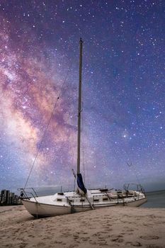 Milky way in the night sky over a shipwreck off the coast of Clam Pass