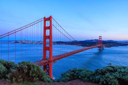 Iconic Golden Gate Bridge and San Francisco city on coast at sunset