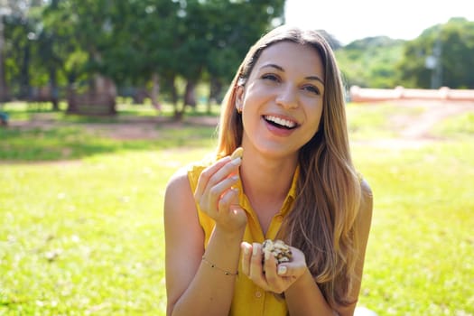 Healthy woman eating Brazil nuts in park on summer