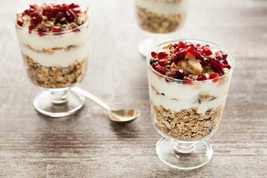 Healthy muesli in glasses on wooden background