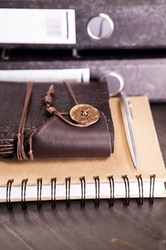 Leather covered vintage retro notebook next to a pile