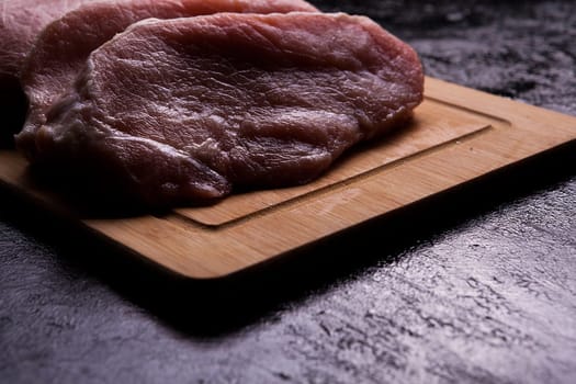Fresh raw meat on wooden board backlit