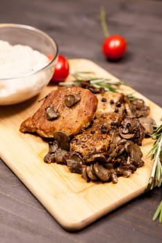 Grilled pork steak, mushrooms cherry tomatoes and a plate with b