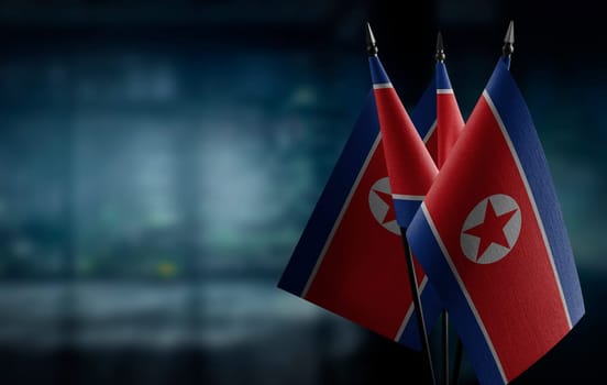 Small flags of the North Korea on an abstract blurry background
