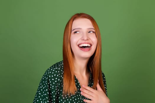 Young red hair woman on green background smile and laugh, in good mood, positive emotions