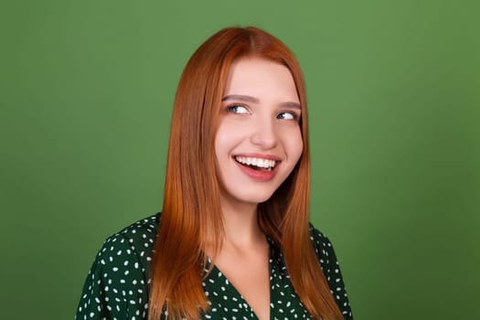 Young red hair woman on green background smile and laugh, in good mood, positive emotions