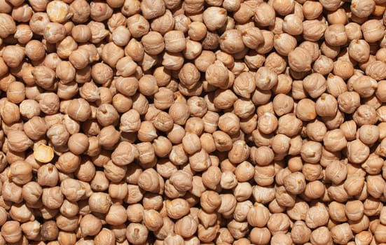 Raw chickpea beans. Top view on chickpea seeds. Food background from a texture of raw chickpeas close-up, top view. Uncooked chickpea.
