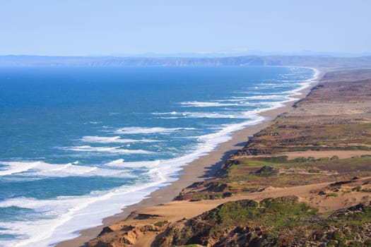 View of long sandy beach and cliffs of Point Reyes on Northern California coast