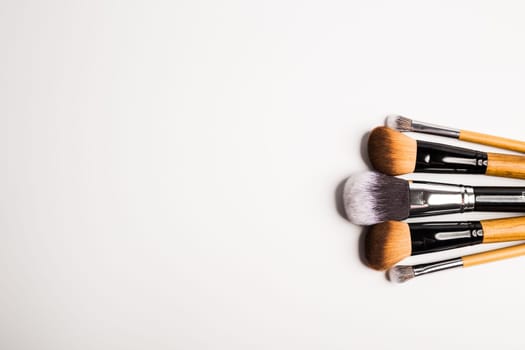 Assorted make up brushes isolated, top view. White background with copy space and empty space for text