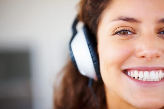 Pretty woman wearing headphones. Closeup of pretty smiling woman wearing headphones