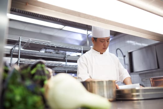 He uses only the finest ingredients. chefs preparing a meal service in a professional kitchen.