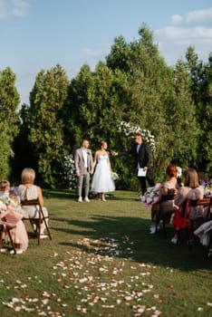 wedding ceremony of the newlyweds on the glade