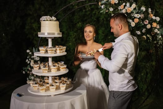 newlyweds happily cut and taste the wedding cake