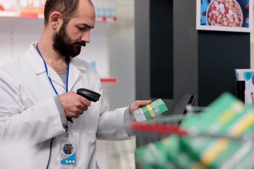 Pharmacist holding store scanner that reads the barcodes on all the pills and packages