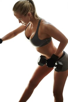 Lift through the burn. a beautiful young woman in workout gear lifting dumbbells.