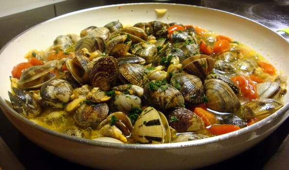 Preparation of a sauce with clams in a pan.