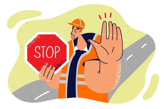 Man in builder uniform shows stop sign and makes caution gesture to warn drivers about road repairs