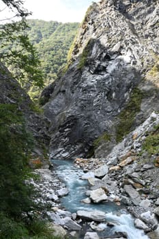 Vertical shot of a river flowing through rocks in Xiulin, Hualien, Taiwan