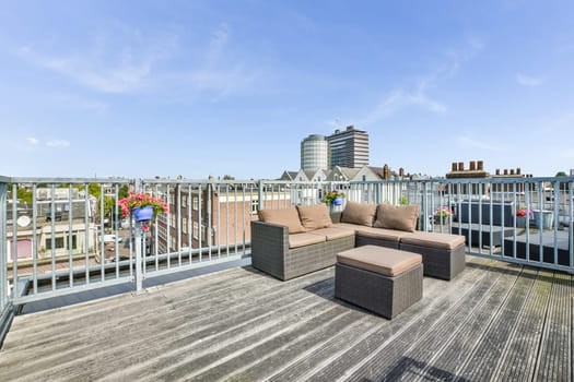 a rooftop deck with a couch and chairs on it