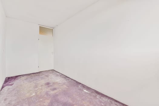 an empty room with white walls and a cement floor