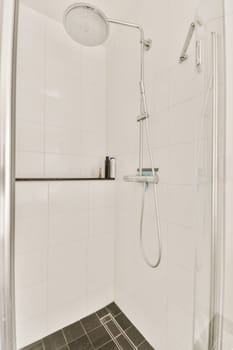 a shower with white tiles and a glass shower door
