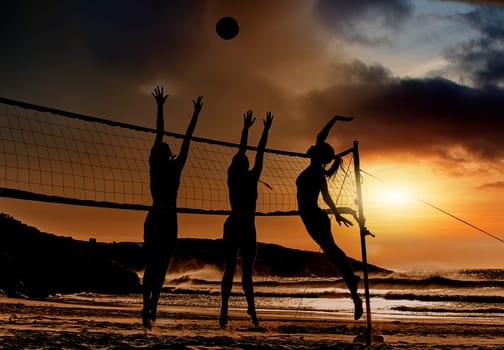 Sports, beach and volleyball at sunset by women silhouette jumping for ball together, fun, travel and summer. Energy, fitness and exercise with sports friends playing beach volleyball game in Brazil