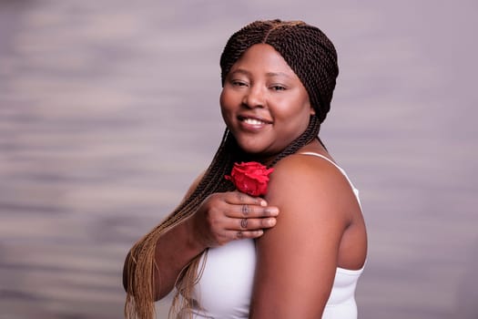Attractive african american model posing with red rose bud