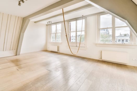 a large white room with wood floors and large windows