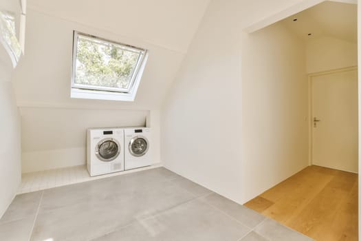 a laundry room with a washing machine and a window