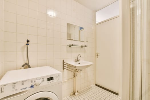 a white bathroom with a washing machine and a sink