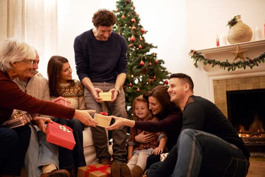 Family, christmas and holiday gift event of mother, dad and children with grandparents happy. Party and celebration event of people giving present box with thank you and gratitude on holiday at home